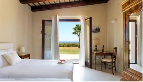 Un dormitorio con una cama y una mesa y una ventana. en Villa Casale by PosarelliVillas, en Bisciano