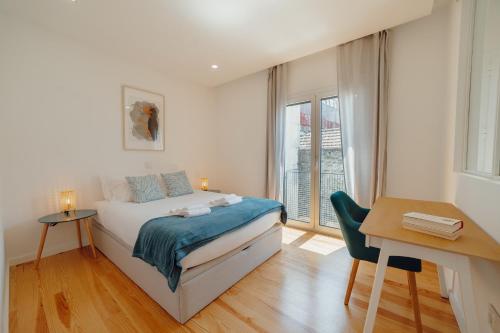 a bedroom with a bed and a desk and a window at Courtyard Oporto Design Apartments by Vacationy in Porto