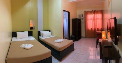 a hotel room with two beds and a bathroom at Coron Vista Lodge in Coron