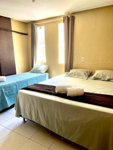 two beds sitting next to each other in a room at Hotel Santiago Juazeiro in Juazeiro do Norte