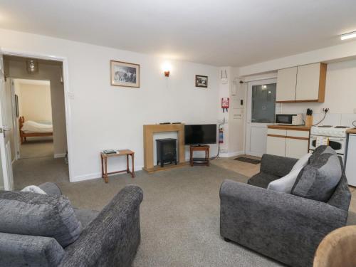 a living room with two couches and a kitchen at Newfield Apartment 2 in Broughton in Furness