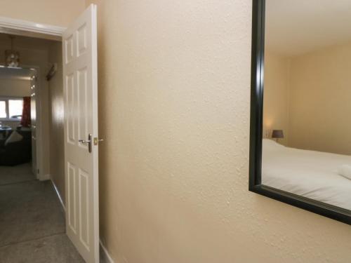 a mirror hanging on a wall next to a bedroom at Newfield Apartment 2 in Broughton in Furness