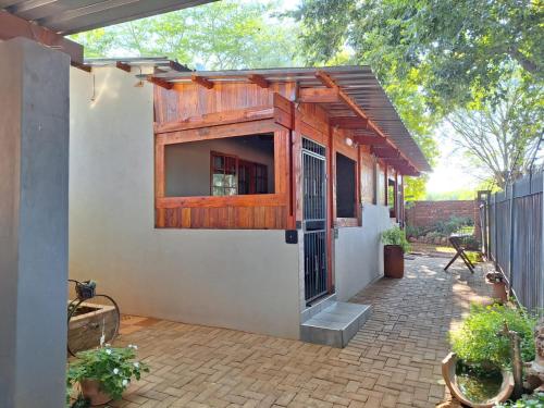 ein Haus mit einer Holztür und einer Terrasse in der Unterkunft 1@Kruger Unit 3 in Mokopane