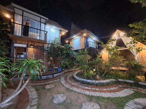a man standing on the balcony of a house at night at Bungalow HTC tuần châu in Ha Long