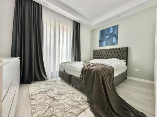 een slaapkamer met een bed en een groot raam bij Double Studio B106 StayInn by Cosmopolis in Ştefăneştii de Jos