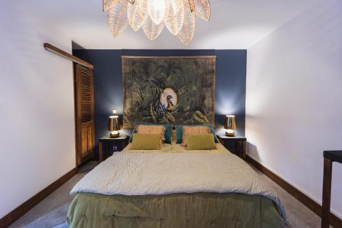 a bedroom with a large bed with a painting on the wall at Coco Lagon accès plage in Saint-Paul