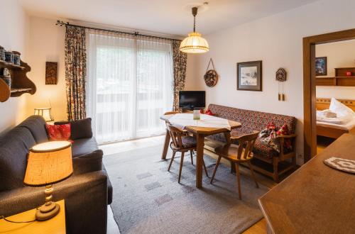 a living room with a couch and a table at Appartementanlage Thermenblick SKI IN & SKI OUT in Bad Kleinkirchheim