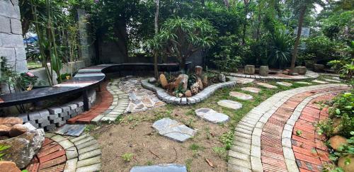a garden with rocks and trees and a bench at Bungalow HTC tuần châu in Ha Long