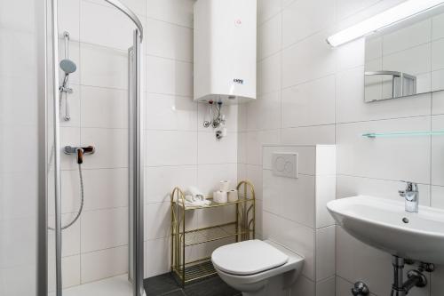 a white bathroom with a toilet and a sink at Appartementanlage Thermenblick in Bad Kleinkirchheim
