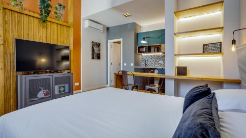 a room with a bed and a tv at Hostellicious Studio in Faro