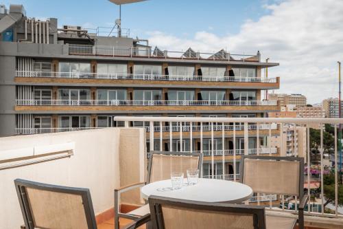 a table and chairs on a balcony with a building at Apartamentos Vistasol in Magaluf