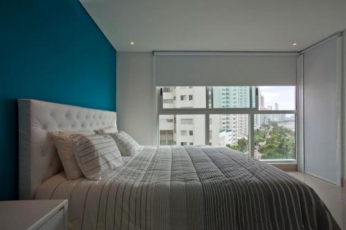 1 dormitorio con 1 cama y ventana grande en MURANO ELITE LUXURY OCEANFRONT BOCAGRANDE., en Cartagena de Indias