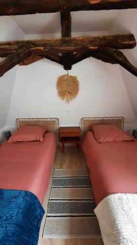 deux lits côte à côte dans une pièce dans l'établissement Gîte Les Placettes, à Sainte-Foy-de-Longas