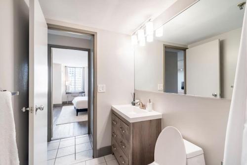 ein Badezimmer mit einem Waschbecken, einem WC und einem Spiegel in der Unterkunft Hartford Heights Skyline Views Await in Hartford