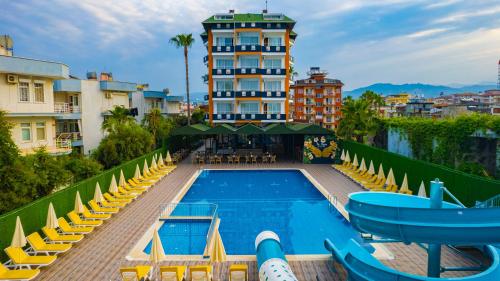 a swimming pool with yellow chairs and a hotel at DE MARE FAMILY Hotel in Konaklı