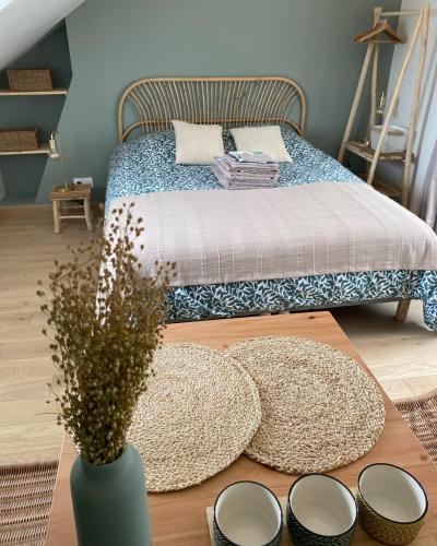 une chambre avec un lit et une table avec des chapeaux et des miroirs dans l'établissement Studio Le nid de pie, à Honfleur