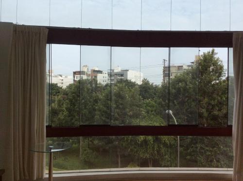 una finestra con vista sugli alberi e sugli edifici di Departamento Estudio a Lima