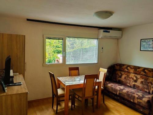 ein Wohnzimmer mit einem Tisch und einem Sofa in der Unterkunft Vikendica Mia Balkana in Mrkonjić Grad