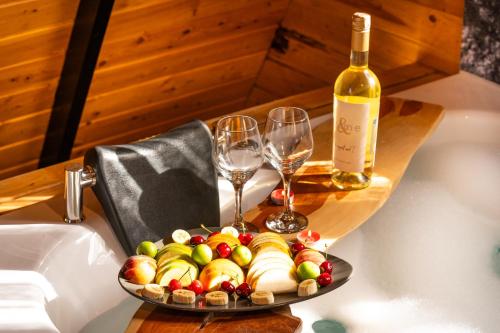 a plate of fruit and wine glasses on a table at Karaöz Sapphire Bungalows in Kumluca