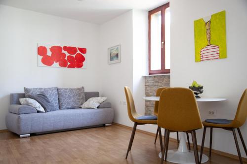 sala de estar con sofá, mesa y sillas en Rosa di Pirano, en Piran