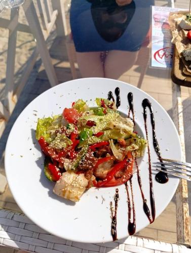 a plate of food with a salad on a table at Shalanda in Odesa