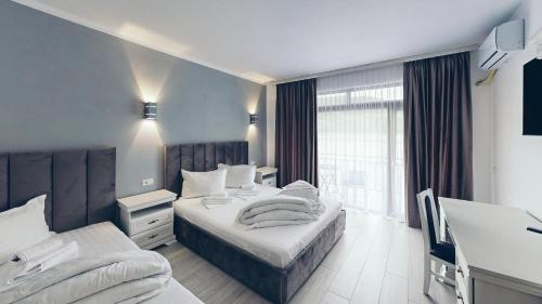 a hotel room with two beds and a window at Pensiunea Rodan in Orşova