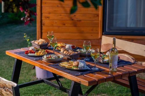 a picnic table with food and glasses of wine at Karaöz Sapphire Bungalows in Kumluca
