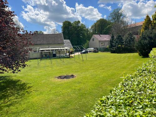 a large yard with a house and a park at Penzion V Podzámčí in Moravská Třebová