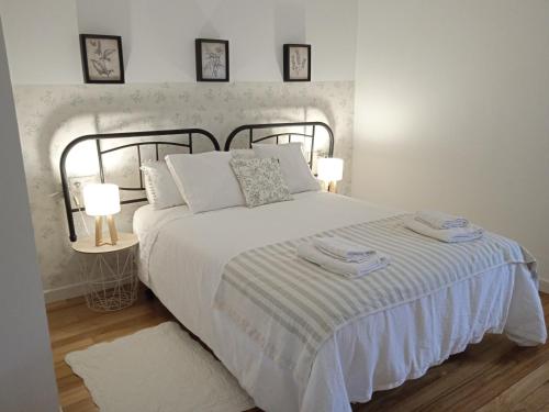a bedroom with a bed with two towels on it at Vicario etxea in Concha