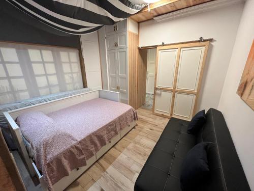 um quarto com uma cama e um sofá em Las Caletillas vacations, 20 meters from the beach em Santa Cruz de Tenerife
