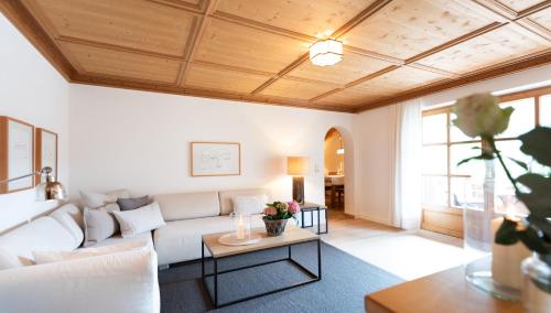 sala de estar con sofá blanco y mesa en Haus Lesch - Stilvolle Appartements mit tollem Bergblick in Kreuth am Tegernsee, en Kreuth