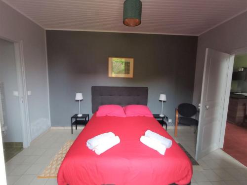 a bedroom with a large red bed with two pillows at Gite cosy 4 pers en vallée de la Creuse in Baraize