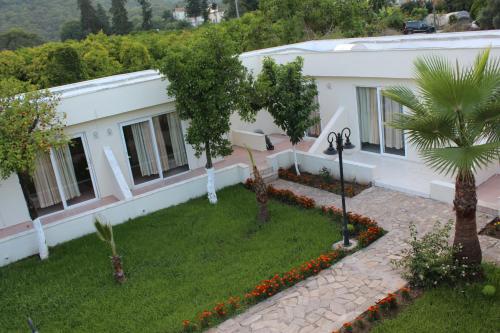 a house with a garden and a palm tree at Hotel Gold Stone in Beldibi