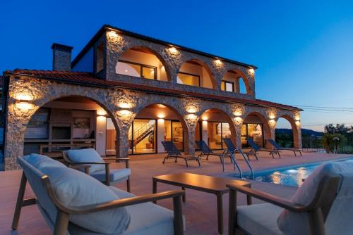 a villa with a swimming pool and chairs and lights at Vista D'Ouro- A luxury villa in the mountains in Ponte da Barca