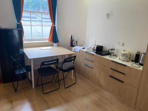 a kitchen with a table and two chairs and a desk at Not Very Quiet But Best location in London