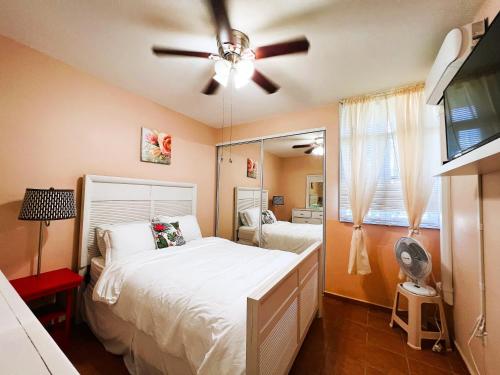 - une chambre avec un lit et un ventilateur de plafond dans l'établissement 3 BR Villa Tranquilidad, à Vega Alta