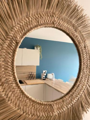 un miroir circulaire dans une cuisine avec un comptoir dans l'établissement Bord de mer: soleil, plage et grande terrasse pour instants de détente (Wifi, clim), à La Grande Motte