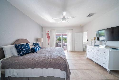 um quarto com uma cama e uma televisão de ecrã plano em Bimini Blue Villa Villa em Alice Town