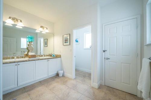 baño con 2 lavabos y espejo grande en Bimini Blue Villa Villa, en Alice Town