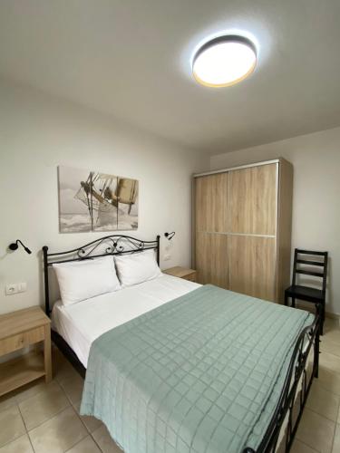 Georgoudi Apartments في نيكيتي: غرفة نوم بسرير كبير مع بطانية خضراء