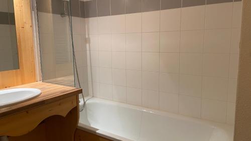 une salle de bain avec un lavabo et une baignoire dans l'établissement Hameau des Eaux d'Orelle 3 Vallées - 2 Studios Communicants, à Orelle