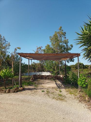 a pavilion with a roof on the side of a road at Appartamento Il Salice in Casa Minnina