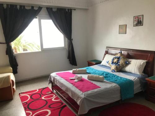 um quarto com uma cama grande e uma janela em Appartement Lallaty em Rabat