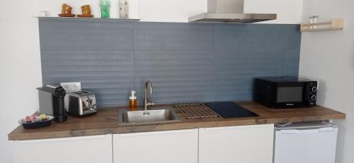 a kitchen counter with a sink and a microwave at La de Simón in A Guarda