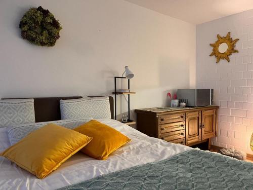 een slaapkamer met een bed met gele kussens en een televisie bij Exil Apartment in Sankt Englmar