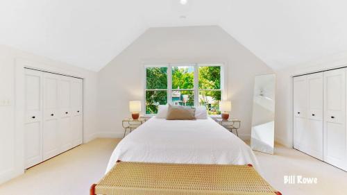 ein weißes Schlafzimmer mit einem großen Bett und einem Fenster in der Unterkunft Douglas Farm House in Douglas