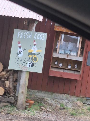 a sign on a pole in front of a store at Twin Deer Lodge in Glenfinnan