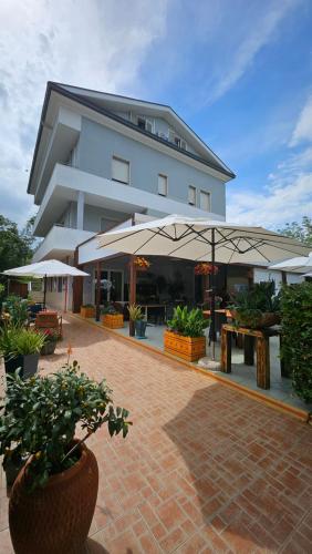 シルヴィ・マリーナにあるHotel Cerranoの建物の前にテーブルと傘
