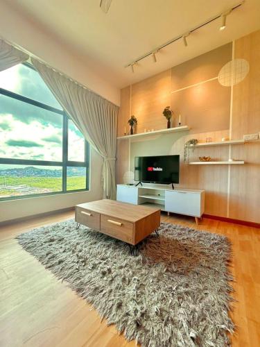 a living room with a coffee table and a large window at imperium residence kuantan in Kuantan