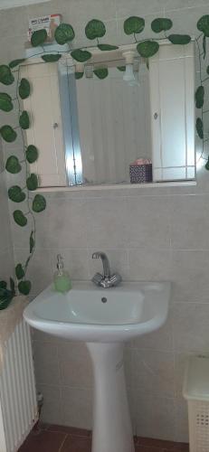 y baño con lavabo blanco y espejo. en Michael's & Kyriaki's House, Kalamoti, Chios, en Kalamoti